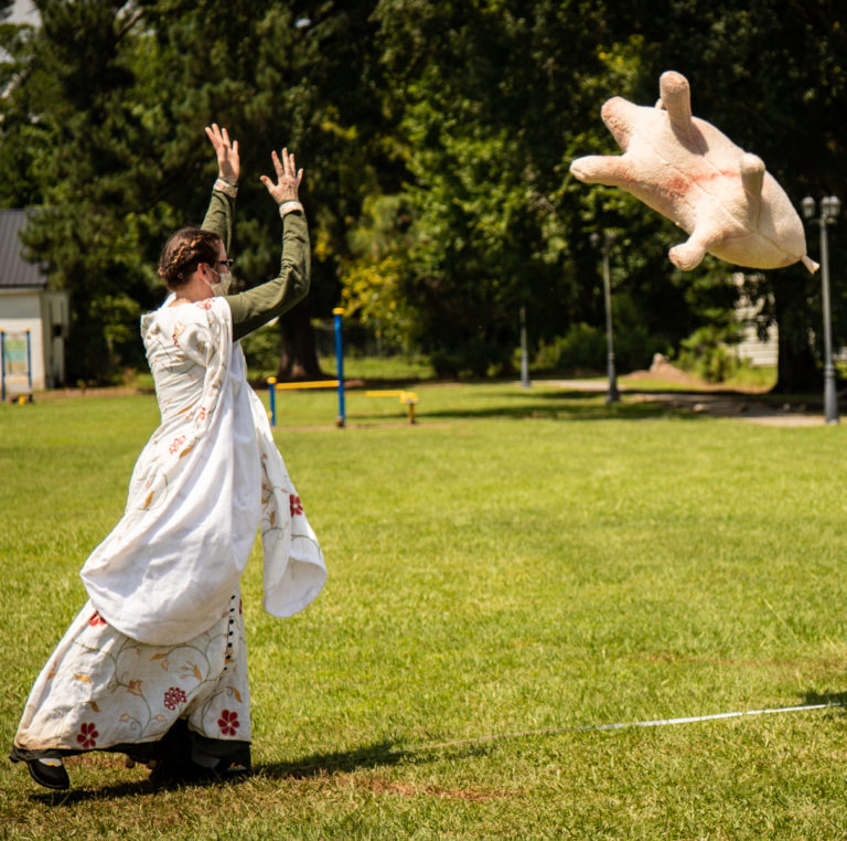 The Queen of Atlantia, tossing a stuffed pig