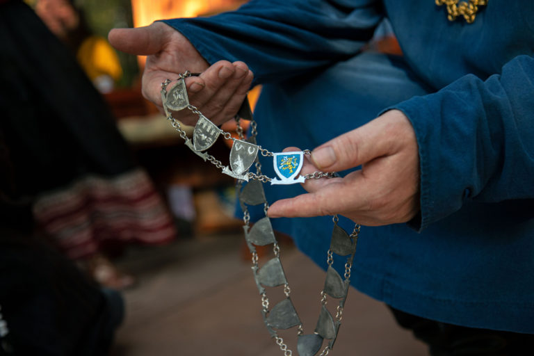 A metal necklace of linked shields displaying heraldry